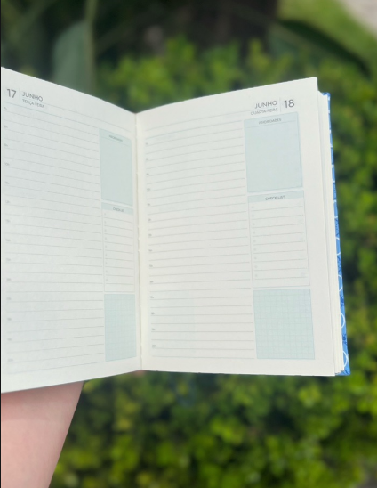 Caderno azul aberto mostrando páginas internas de planejamento